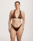 Woman wearing a brown bikini against a white background