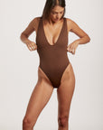 Woman wearing a brown swimsuit on a white background