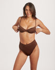 Woman wearing a brown bikini set on a white background