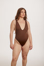 Woman wearing a brown swimsuit on a white background