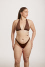 Woman wearing a brown bikini against a plain background
